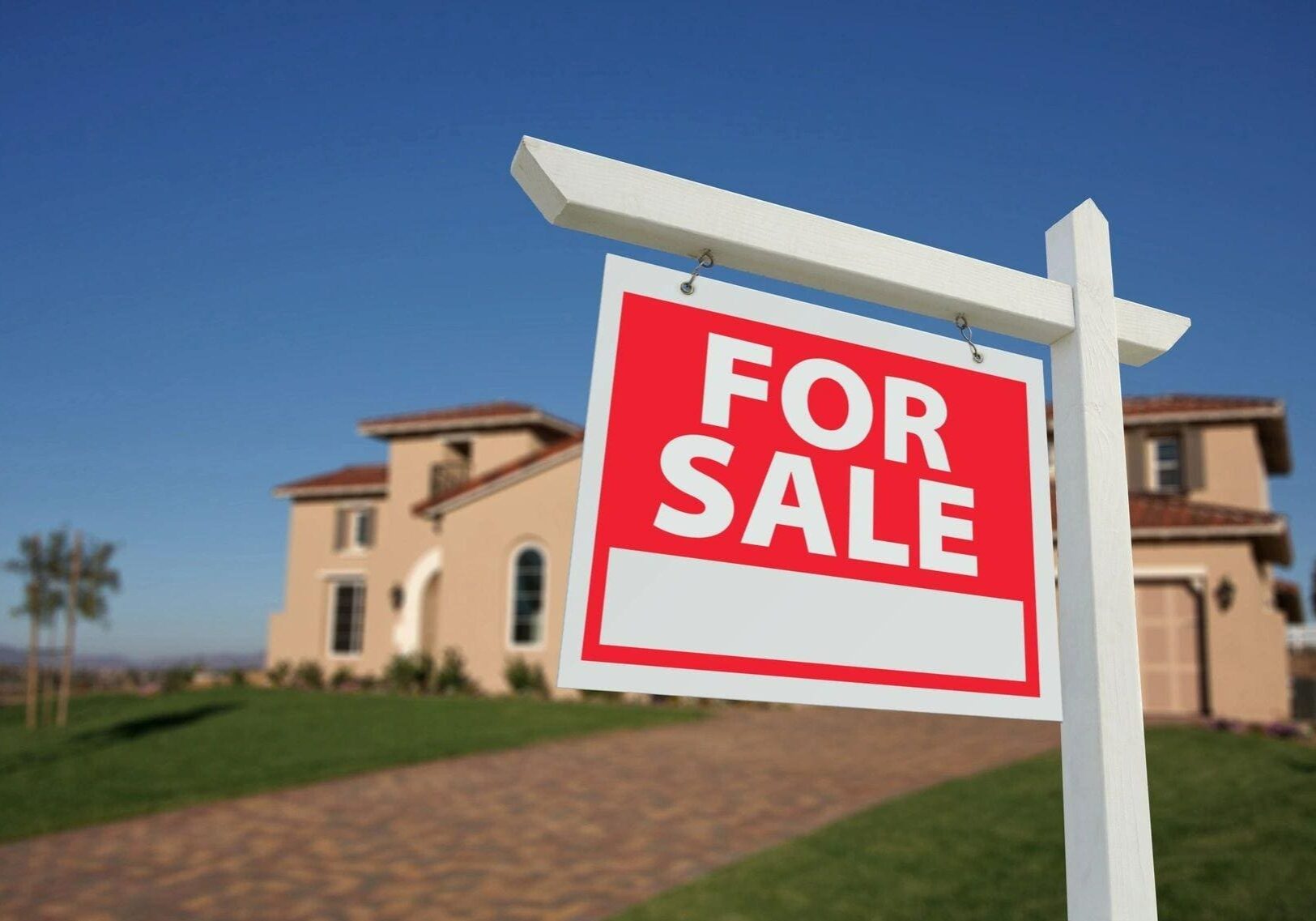 A for sale sign in front of a house.